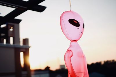 Close-up of alien shape balloon against sky during sunset