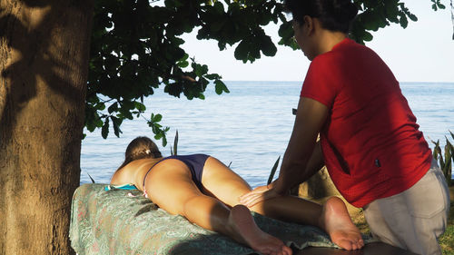 Asian woman massage therapist doing massage to girl. 