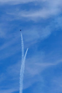 Low angle view of airplane flying against blue sky