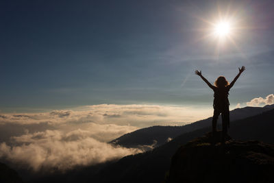 Silhouette man standing on mountain against sky during sunset