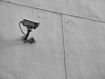 Low angle view of security camera on wall