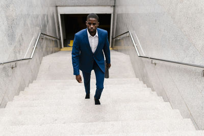 Businessman moving up on staircase at subway in city