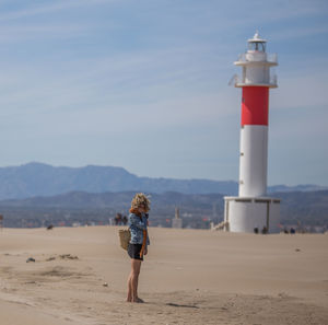 Full length of woman standing against lighthouse