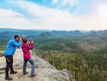 Man takes photo of photographing woman with phone. photographer with eye at viewfinder talk woman