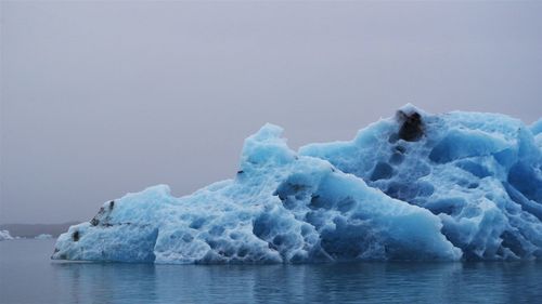 Frozen sea against clear sky