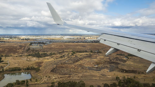 Airplane flying over landscape against sky