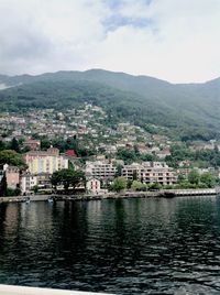 River by townscape against sky
