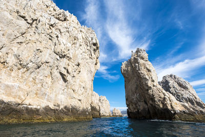 Scenic view of rock formation in sea against sky