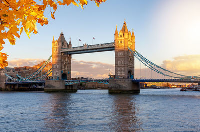 Bridge over river against sky in city