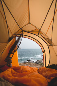 Scenic view of sea against sky seen through tent