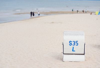 Close-up of text on beach against sky