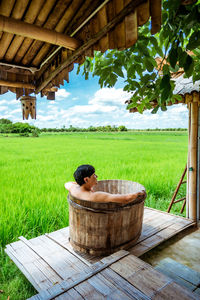 Man relaxing on field against trees