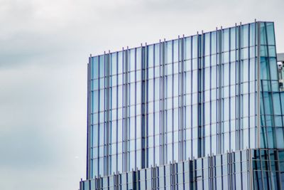 Low angle view of glass building against sky