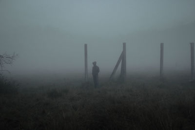 Man standing on field during foggy weather