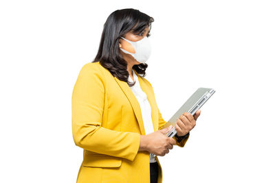 Side view of woman using smart phone against white background