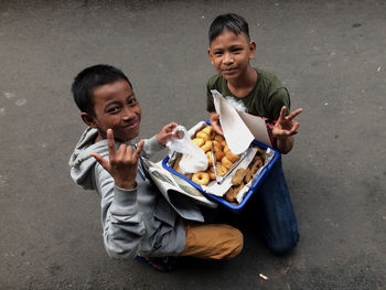 Portrait of a smiling boy holding ice cream on floor