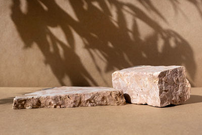 Podium for product promotion display. natural pedestal. stone showcase with shadow of leaf.  mockup