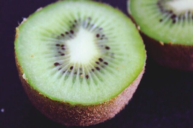 food and drink, close-up, food, indoors, healthy eating, freshness, still life, fruit, cross section, green color, studio shot, no people, slice, black background, seed, circle, organic, high angle view, selective focus, halved