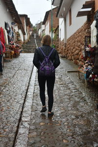 Full length rear view of woman walking on street