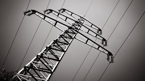 Low angle view of electricity pylon against clear sky