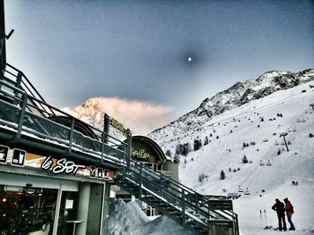 People on snow covered mountain against sky