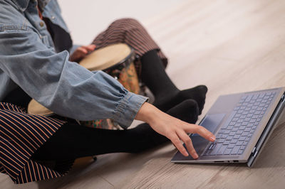 Low section of woman using laptop while sitting at home