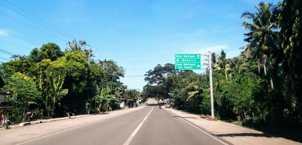 Road by trees against sky in city, medellin, cebu