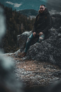 Young man sitting on rock