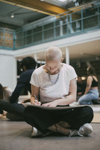 Bald female protestor making signboard in building