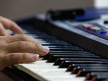 Cropped hands of person playing piano