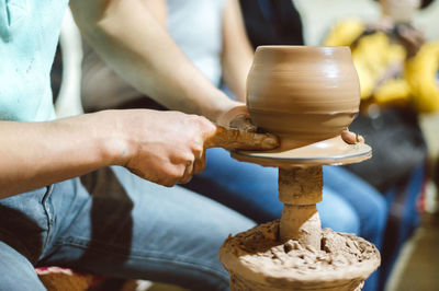 Midsection of man working on pottery wheel