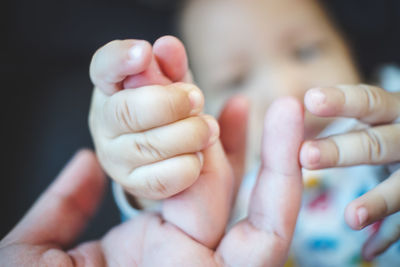 Cropped hand of baby holding mother hand 
