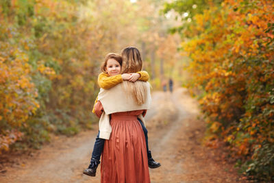 Woman with umbrella on tree during autumn