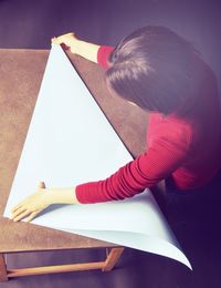 Woman folding paper at table in home