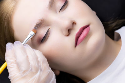 Close-up of woman applying make-up