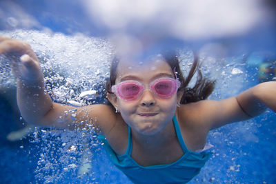 Close-up portrait of happy girl swimming in water