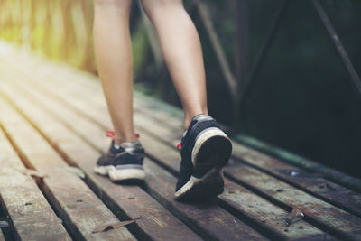 Low section of woman walking on footpath