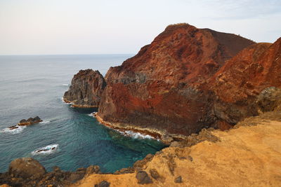 Rock formations by sea against sky