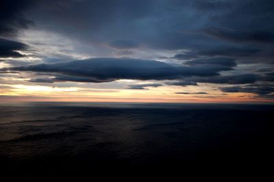 Scenic view of sea against dramatic sky during sunset