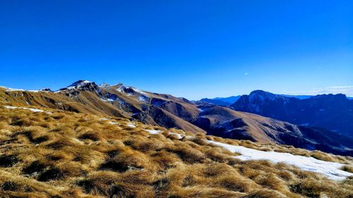 Scenic view of snowcapped mountains against clear blue sky