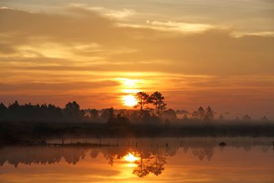 Scenic view of lake against romantic sky at sunset