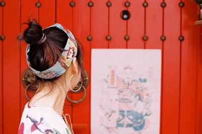 Rear view of woman in red wall