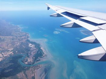 Aerial view of airplane wing over sea