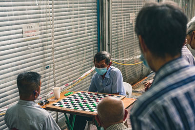 Rear view of people sitting on table