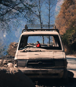 Rear view of man driving car on field against sky