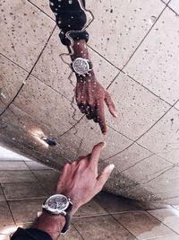 Cropped image of man touching wet glass wall