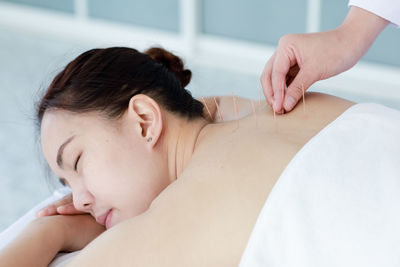 Midsection of shirtless baby lying on bed