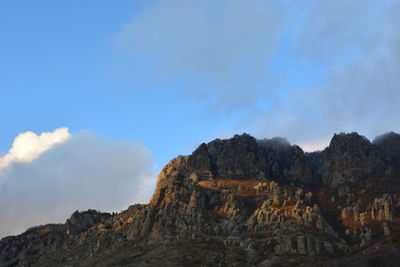 Low angle view of mountain against blue sky