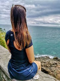 Rear view of woman looking at sea against sky