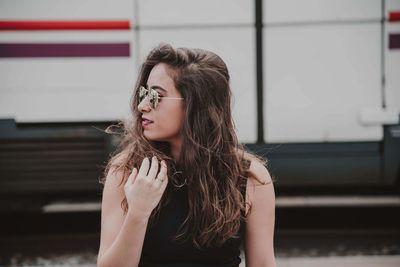 Fashionable young woman wearing sunglasses in city